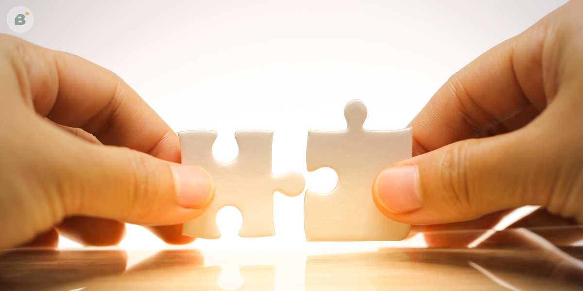 Two hands holding a piece of jigsaw puzzle, symbolising the process of assembling different marketing elements